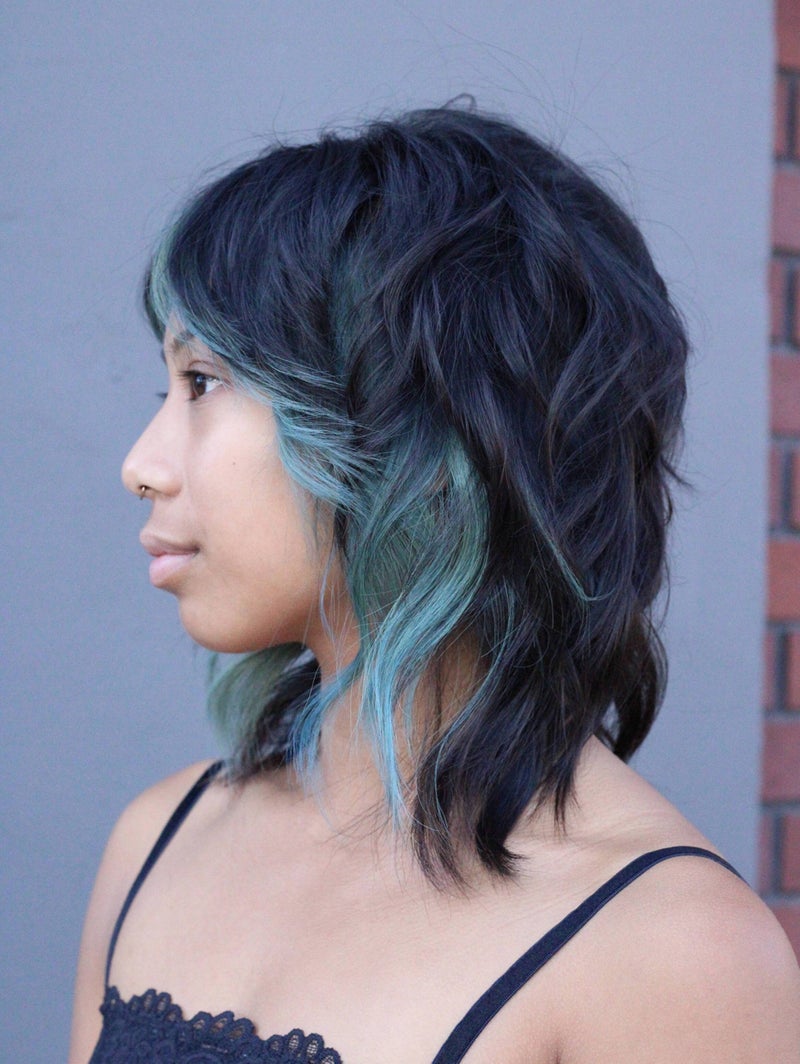 Client with a black-to-teal color melt on a wavy lob by Hope
